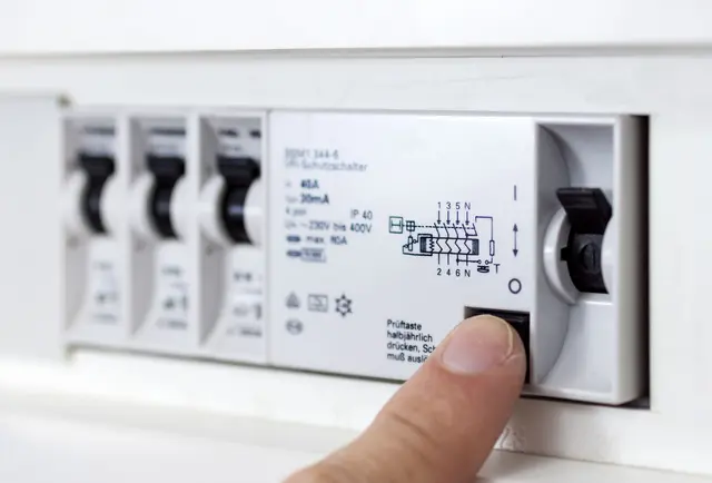 Ein Facharbeiter prüft Elektroinstallationen in einem Neubau – für normgerechte Sicherheit und vollständige Dokumentation.